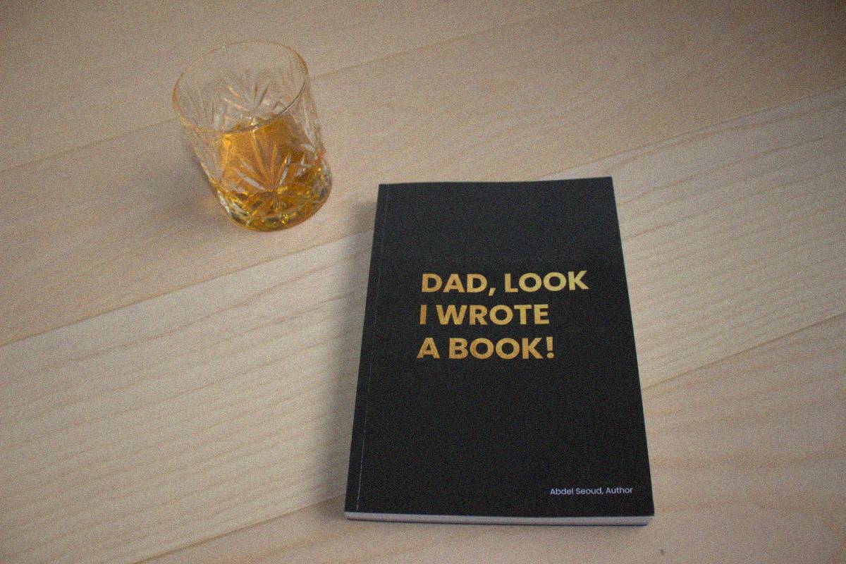 Front cover, on a table next to a glass of whisky